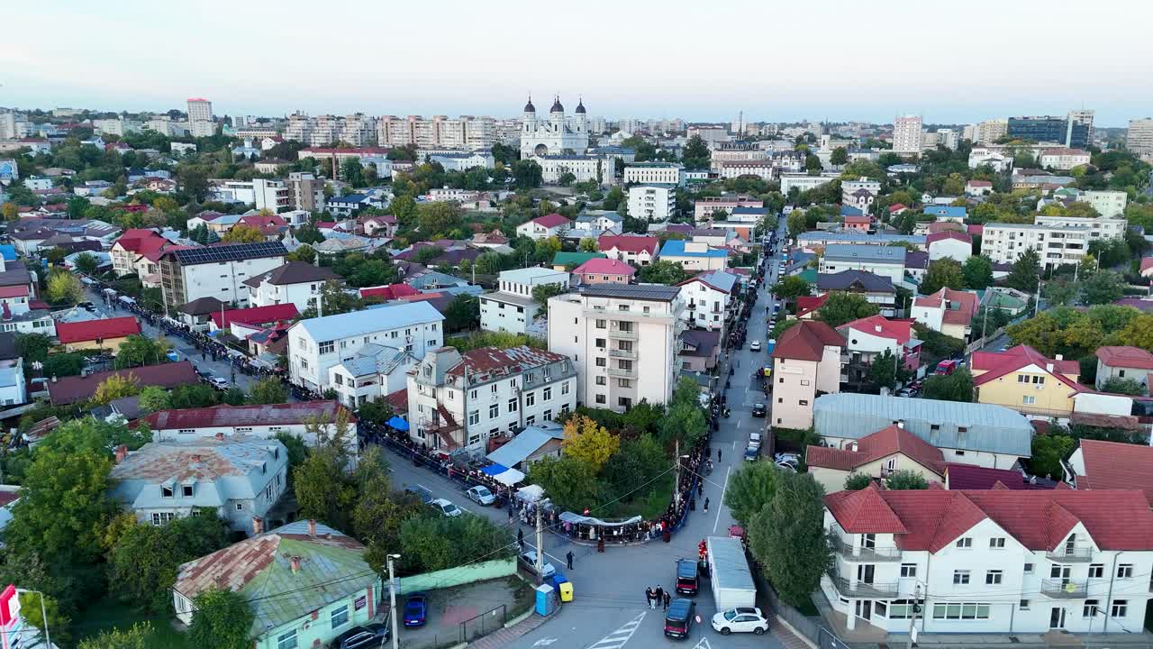 Drone aerial video showing a long line of people walking toward the Metropolitan Cathedral in Iasi, Romania, during the Saint Parascheva religious pilgrimage