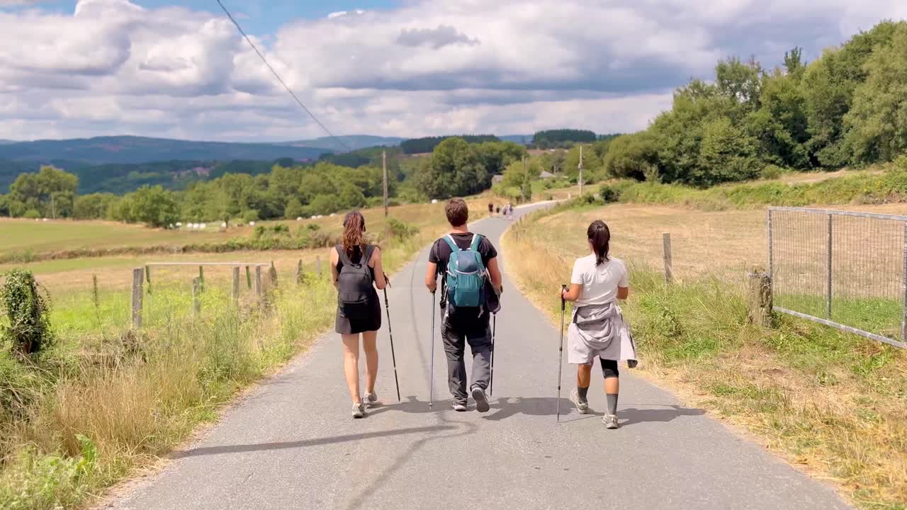 Group of people walking the Camino de Santiago in Spain, experiencing pilgrimage, culture, and spiritual journey through scenic rural landscapes