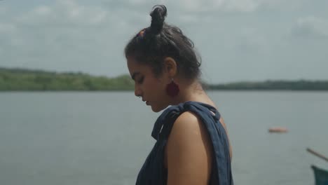 Cinematic-close-up-shot-of-an-Indian-fashion-model-wearing-a-blue,-red-and-orange-dress-walking-on-the-beach-in-Slow-Motion