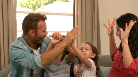 Glückliche-Familie-Auf-Dem-Sofa-High-Five