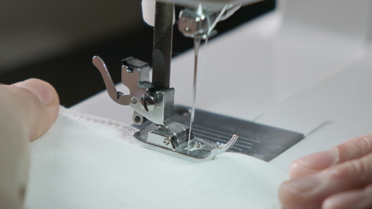 Sewing machine working close up view in slow motion. Clothing industry concept.
