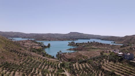 Flying-over-rows-of-trees-towards-Green-lake-turquoise-waters-in-the-valley-of-the-Taurus-mountains-in-Turkey