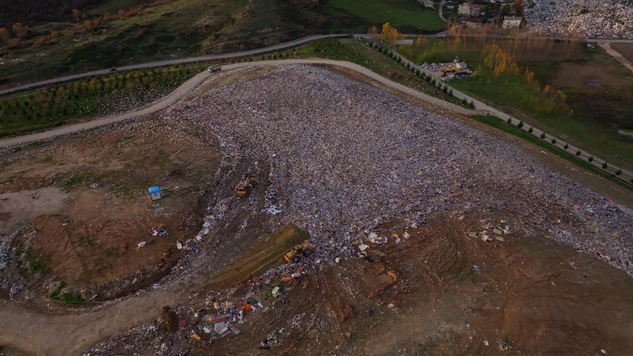 Drone shot of mountains of rubbish filling an open dumping ground