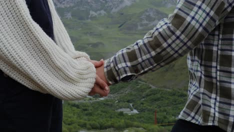 pareja de manos en las montañas