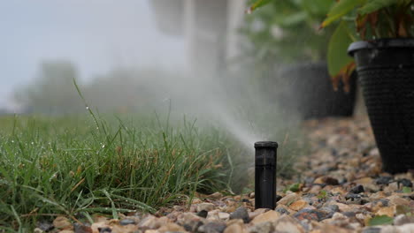 Rainbird-3500-Rotorzahnradantrieb-In-Einem-Felsbett,-Das-Den-Vorgartenrasen-Bewässert