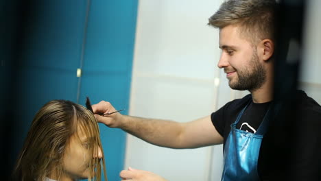process of cutting hair. hair dresser is dyeing hair of beautiful woman in barber shop