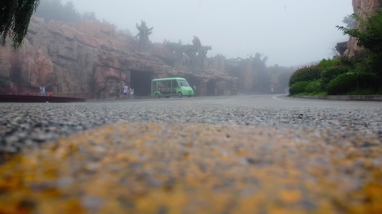 비가 오는 날 폭풍우와 여행객을 마주하는 안개나 가운 비가 내리는 녹색 코치 차량의 낮은 각도 촬영