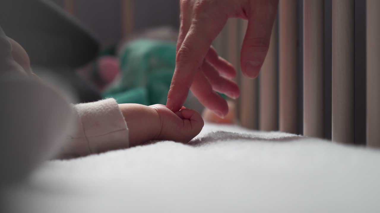 엄마는 부드럽고 천천히 잠자는 신생아의 손과 작은 손가락을 만져라.