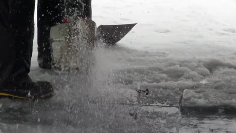 cutting thick lake ice with a chainsaw