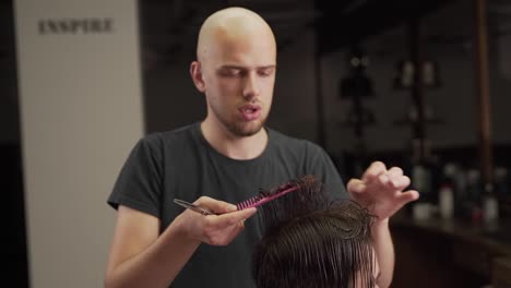 retrato de un peluquero calvo que realiza un corte de pelo masculino