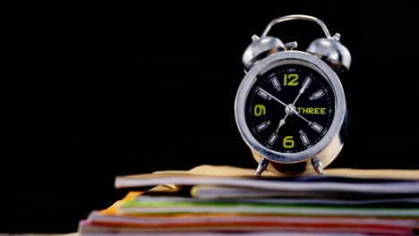 alarm clock on book stack