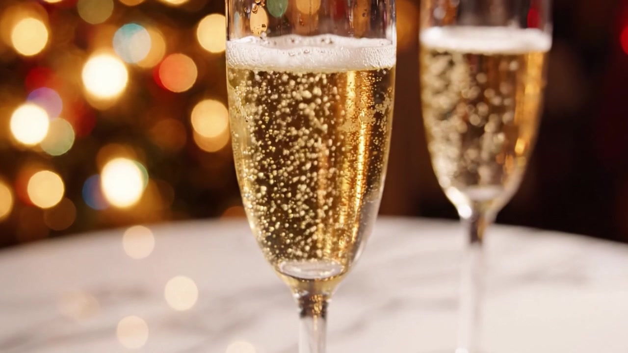 Una celebrazione di bollicine scintillanti: Due eleganti calici di champagne appoggiati su una superficie di marmo su uno sfondo splendidamente illuminato.