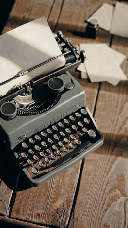 vintage typewriter on a wooden desk with papers and camera