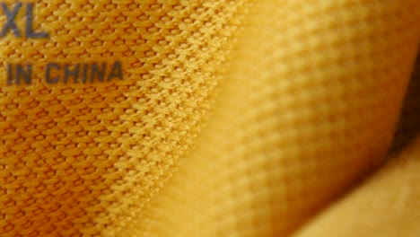 close-up of a yellow garment tag with size and country of origin