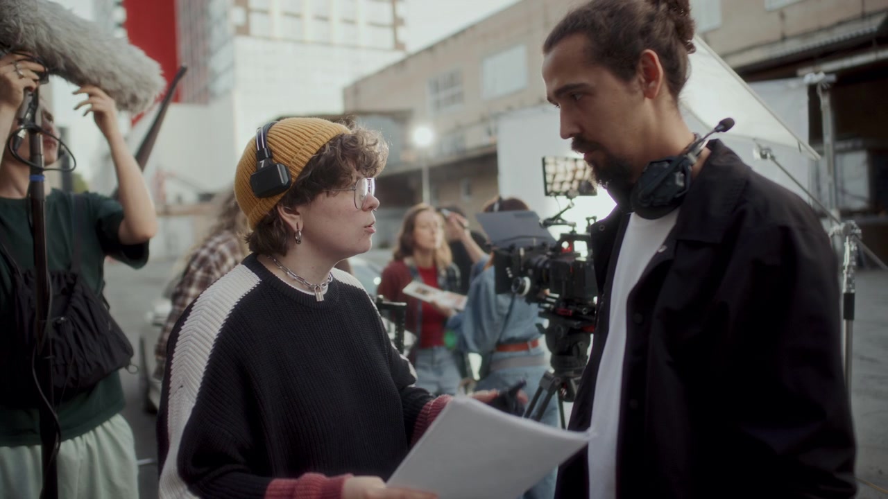 Regista e cameraman discutono la sceneggiatura su un set cinematografico all'aperto