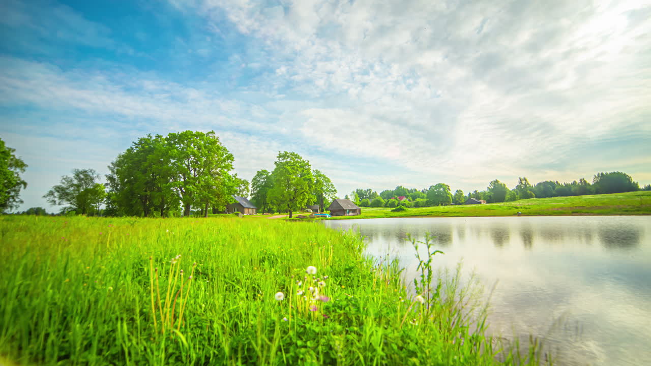 녹색 풍경의 호수 근처에 있는 아름다운 광각 집들, 낮부터 밤까지의 시간 경과