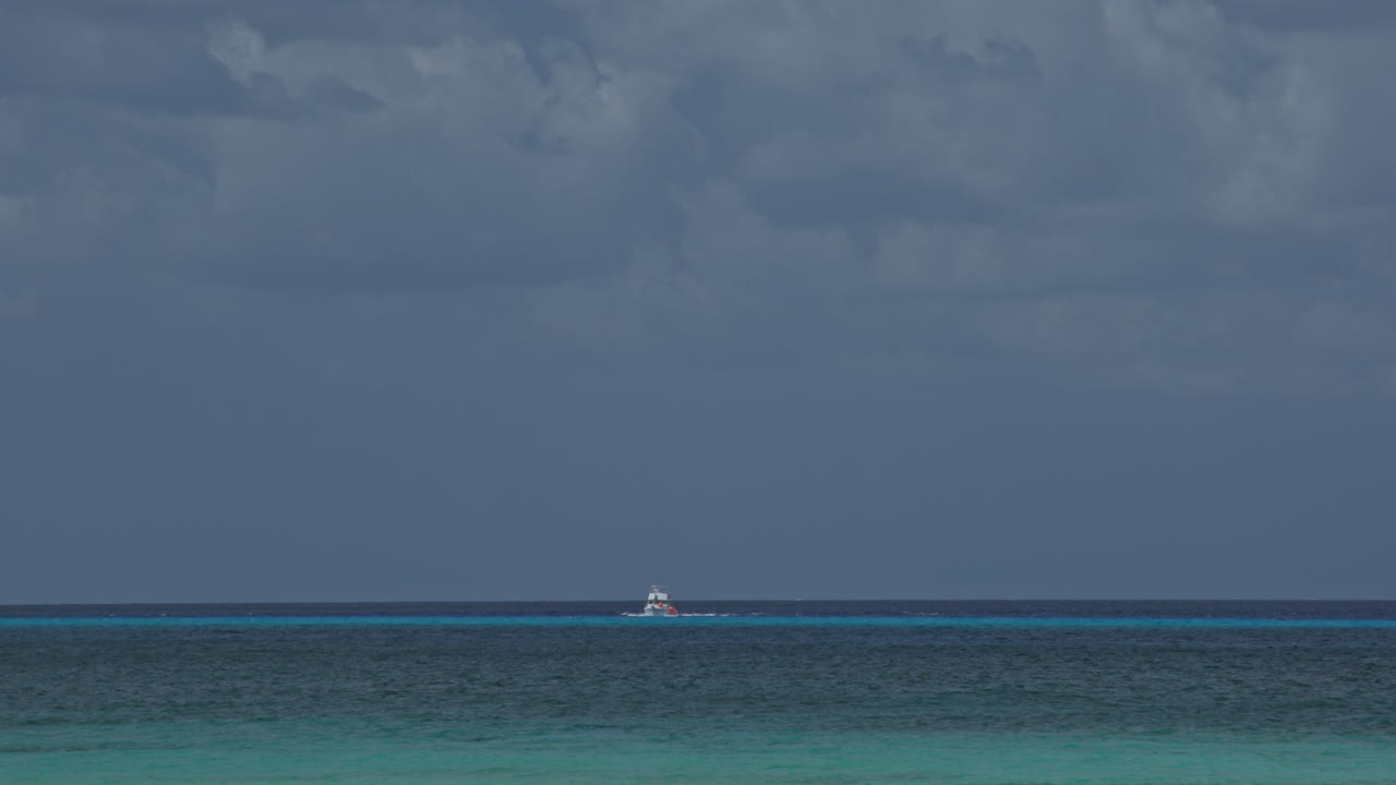 Lille hvid båd sejler i det blå vand ved Cozumel