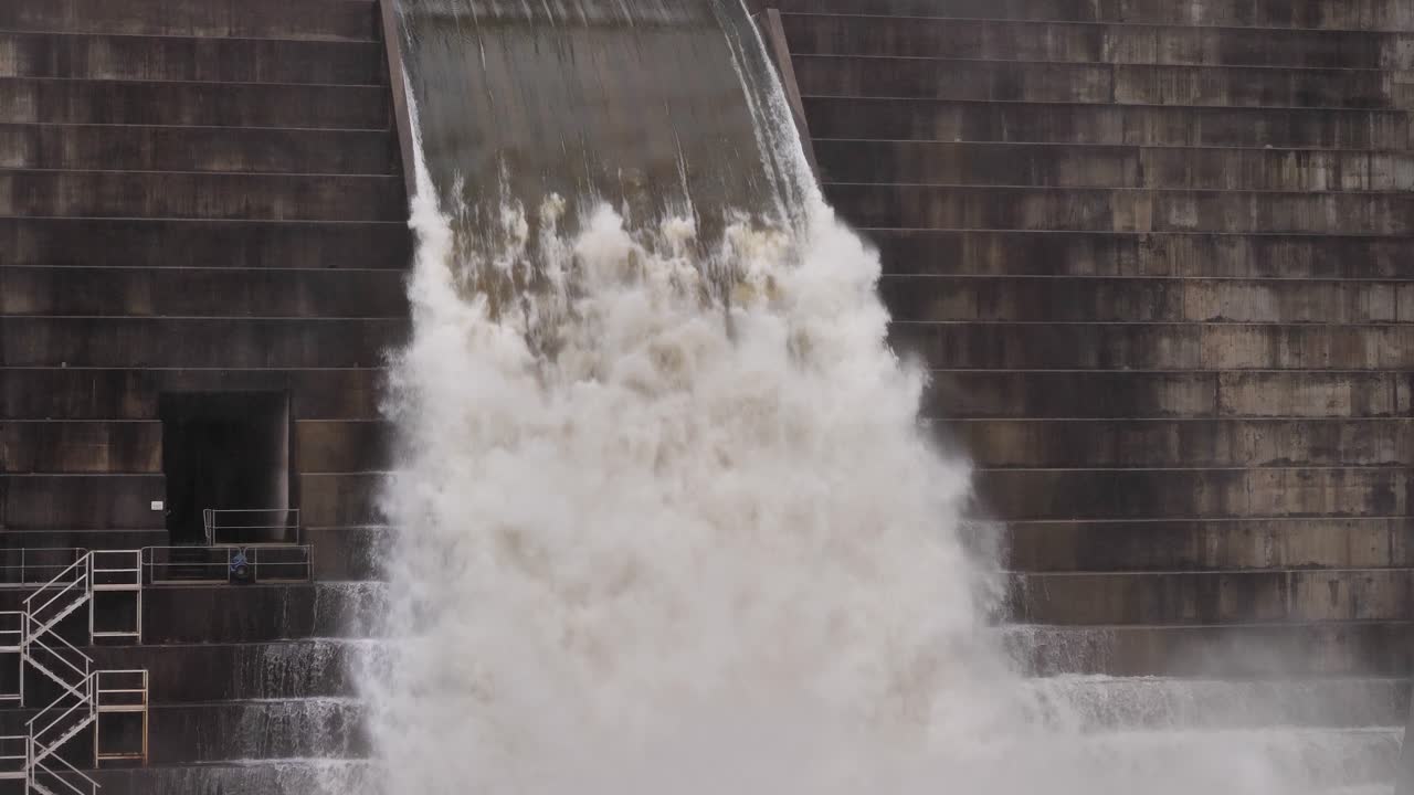 Medium handheld shot of Hinze Dam under heavy rain and water overflow during La Ni&ntilde;a, Gold Coast Hinterland, Queensland, Australia