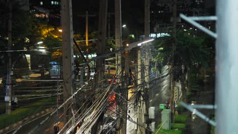 rainy night city street scene with electrical wires