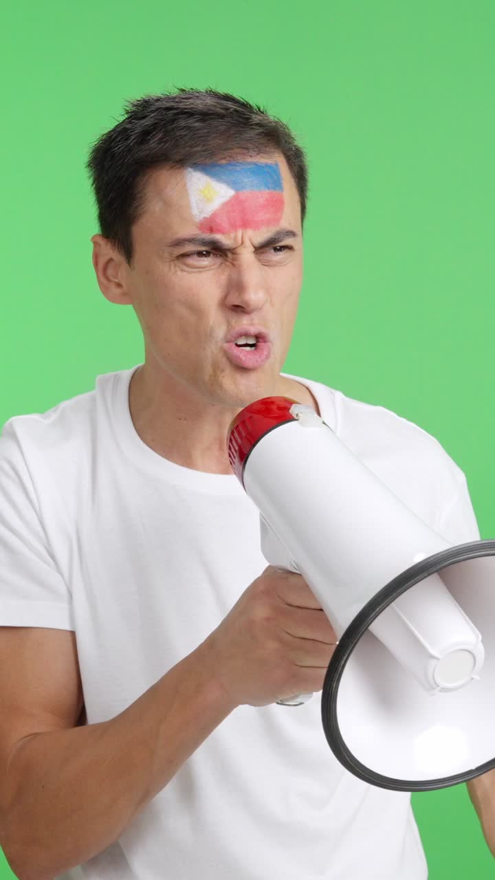 Excited man with philippine flag on face using a megaphone