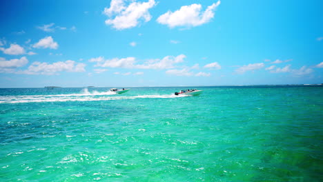 two boats speeding on tropical ocean heading towards the ile aux fouquets