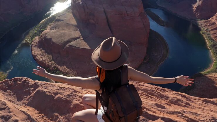 Junge Frau mit ausgebreiteten Armen am Horseshoe Bend Aussichtspunkt