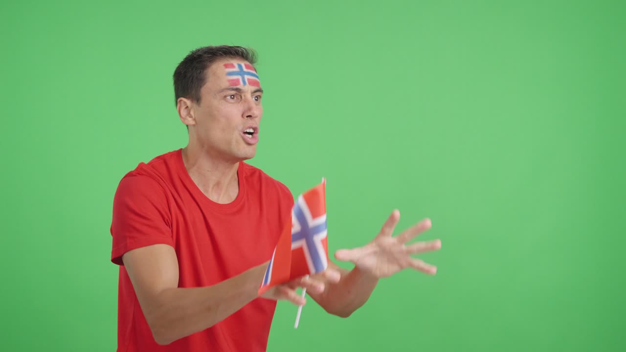 Man cheering for Norway waving a national flag looking away