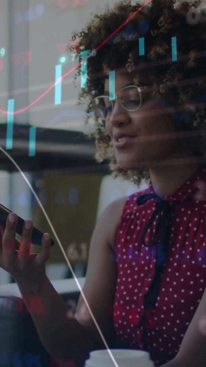 Forretningskvinde arbejder på kontor og bruger smartphone med animation af finansielle diagrammer.