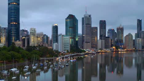 zoom in aerial view of brisbane city cbd and parked boats in early morning, qld australia