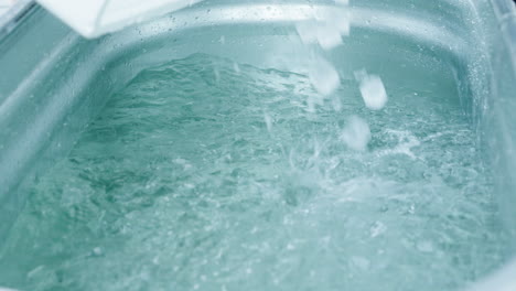 wim hof 얼음 목욕 체험을 위해 강철 욕조에 얼음 조각 채우기