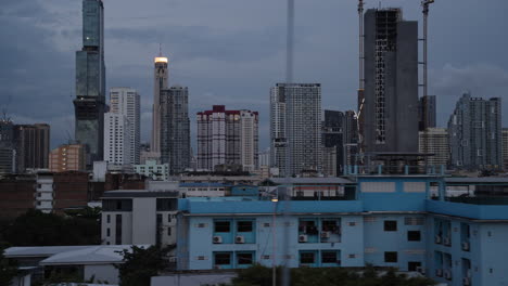 living in bangkok suburbs skyline in the back at night dusk, bangkok moving on the road along the skyline, bangkok cinematic establisher