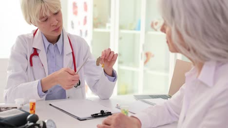 Doctor showing hearing aid to patient