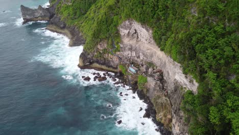 aerial descent upon peguyangan waterfall, nusa penida - indonesia