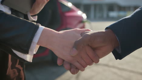 business handshake near electric car