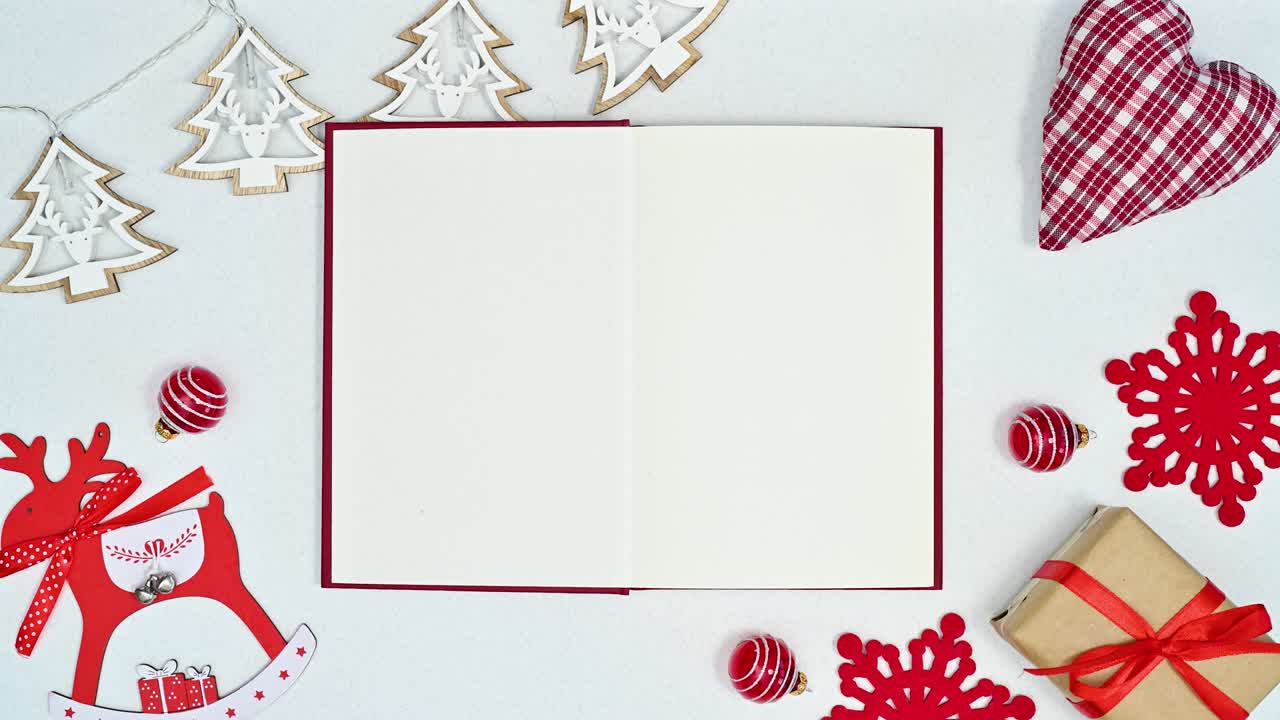 moviendo decoraciones de navidad y luces parpadeantes alrededor de libro abierto en tema blanco.