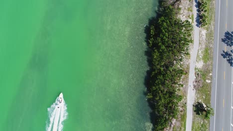 vista de pájaro de un barco a toda velocidad a través de los cayos de florida junto a la autopista de ultramar