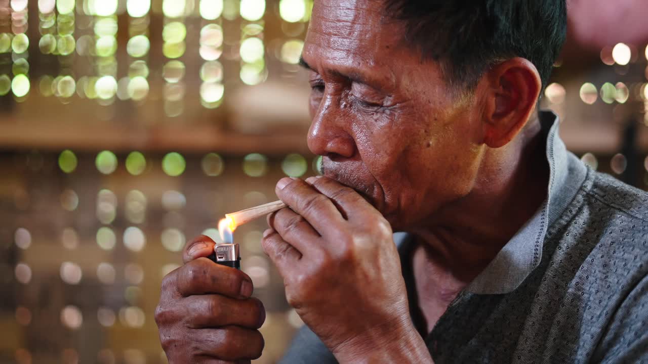 Man smoking a burning stick
