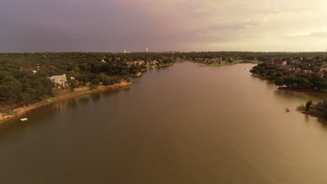 aerial drone flight over lake lewisville in texas after a storm.  a beautiful sunset cast light across the sky and lake.  this is the cove near sunset point park.