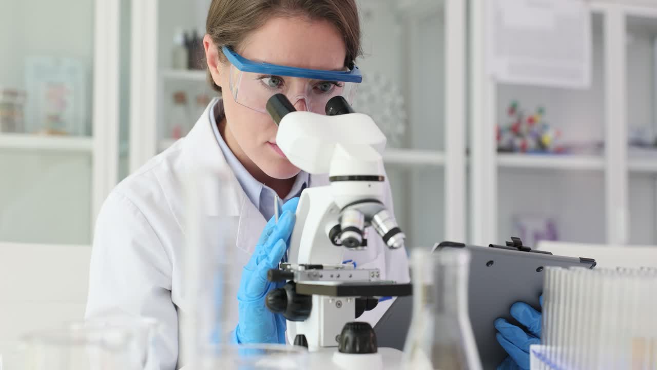 Scientist working with a microscope in a lab