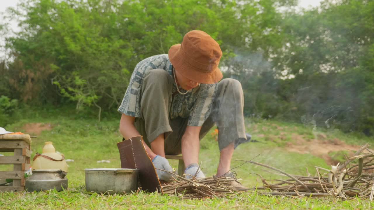 한 남자가 캠프 파이어를 만들고, 나무를 추가하고, 불에서 나오는 연기, 모닥불, 불을 피우고, 캠프파이어를 만드는 캠프파이어, 느린 동작