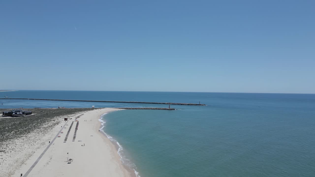 Aerial view of umbrellas and restaurant on the beach in the early morning facing the sea on the island, Algarve region, Portugal
