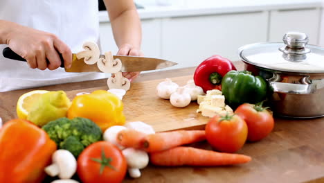 Woman-slicing-mushrooms-on-a-chopping-board