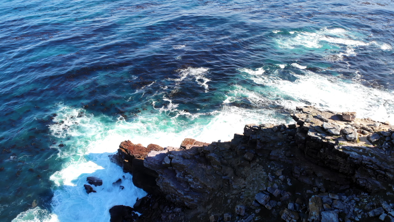 Aerial Rocky Coastline With Crashing Waves Turquoise Ocean Spray Pounding Jagged Granite Cliffs, Drone. Media
