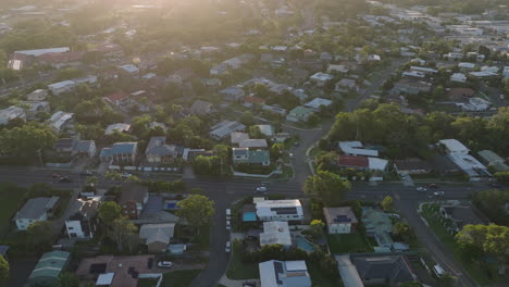 Aerial-Drone-Flyover-Residential-Suburban-Streets-With-Cars-Driving-In-Neighborhood-At-Sunset,-4K