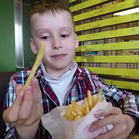young boy eating french fries