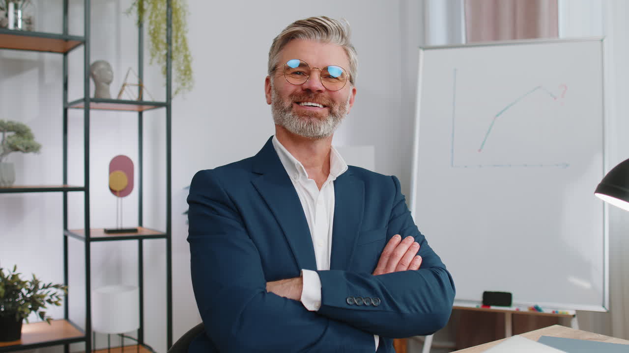 hombre de negocios maduro sentado en la oficina en el lugar de trabajo cerrando el ordenador portátil después de terminar el trabajo remoto