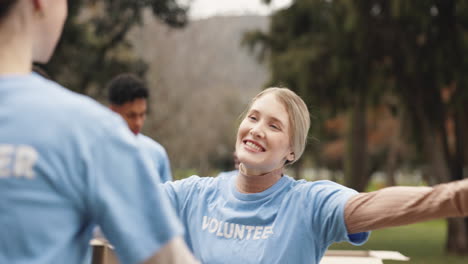 two women volunteers hug each other in a park