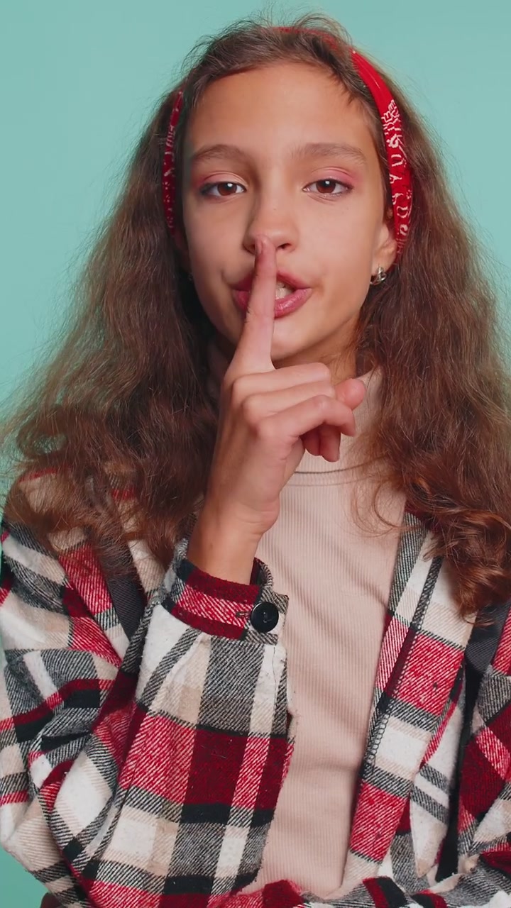 Ragazza preadolescente preme il dito sulle labbra fa silenzio segno di silenzio non dice pettegolezzi segreto silenzio