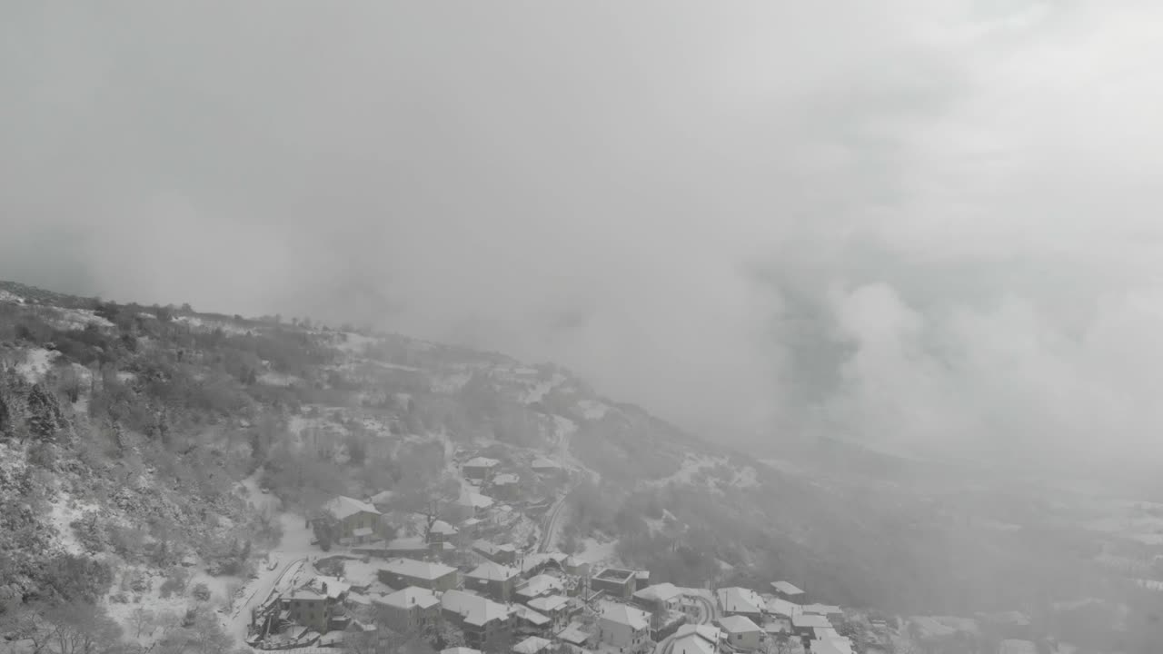 Aerial footage of snowy mountains inside the clouds