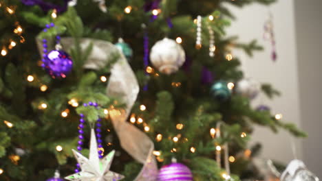 traditional christmas xmas tree decorated with ball ornaments beads ribbons lights purple white blue silver